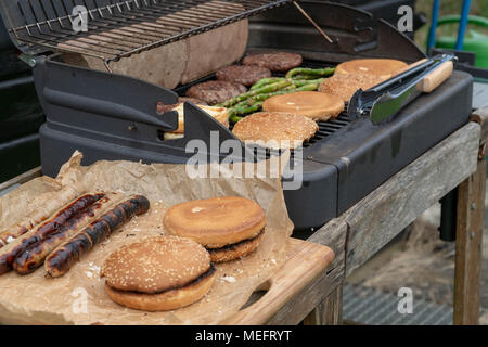 Hamburger Set. The person is going to grill beef patties, sausages, grilled cheese and asparagus Stock Photo