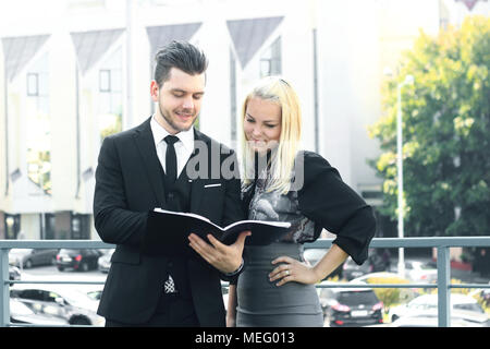 couple of employees reading documents standing near the office Stock Photo