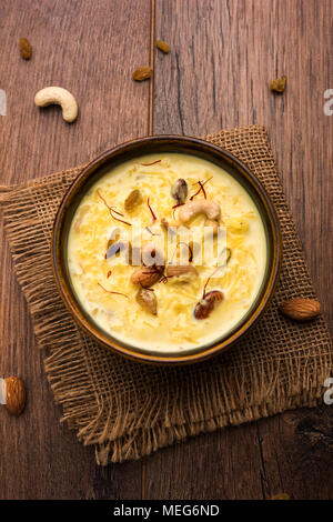 kheer or rice pudding is an Indian dessert in a brown terracotta bowl with dry fruits toppings Stock Photo