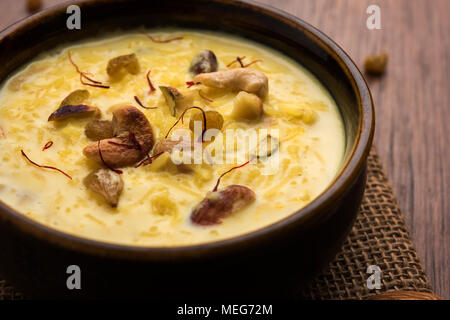 kheer or rice pudding is an Indian dessert in a brown terracotta bowl with dry fruits toppings Stock Photo