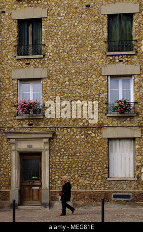 Local walking past a town home on the outskirts of Paris. Stock Photo