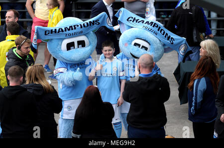 Manchester City fans celebrate being champions with mascots Moonbeam and Moonchester before the Premier League match at the Etihad Stadium, Manchester. Stock Photo