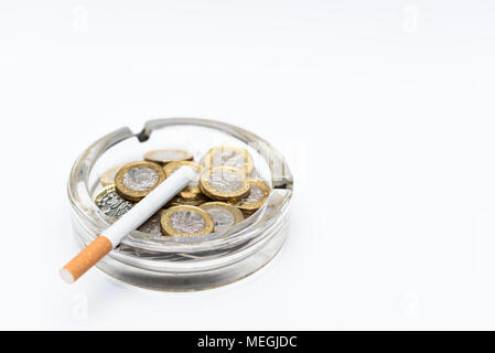 Cigarette and British Pound Coins in an Ashtray Stock Photo