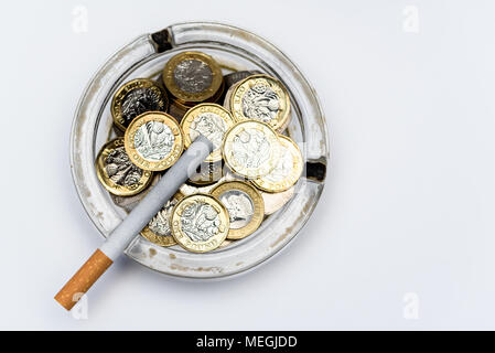 Cigarette and British Pound Coins in an Ashtray Stock Photo