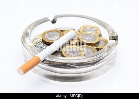 Cigarette and British Pound Coins in an Ashtray Stock Photo