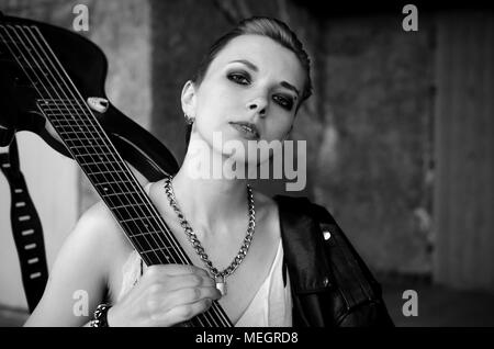 Female rockstar with guitar. Black and white photo Stock Photo