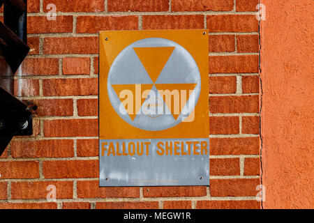 Orange 'Fallout Shelter' sign on a brick wall. With North Korea performing nuclear missile tests, Fallout Shelters may become more popular I Stock Photo