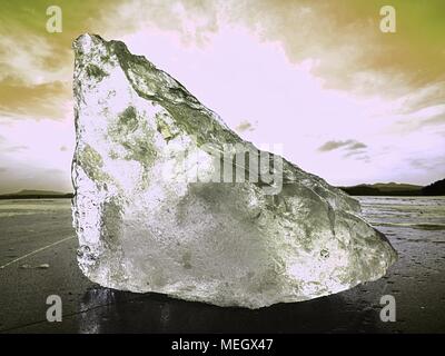 Beautiful epic ice crystal in the frozen bay.  Sun rays reflection in cracks, backlight  of the setting sun. Stock Photo