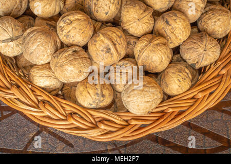 Walnuts in a wooden bowl on a wooden table walnuts with shells Stock Photo
