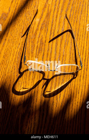 Early morning sunlight casts graphic shadows on wooden table Stock Photo
