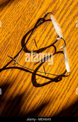Early morning sunlight casts graphic shadows on wooden table Stock Photo