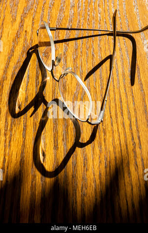 Early morning sunlight casts graphic shadows on wooden table Stock Photo