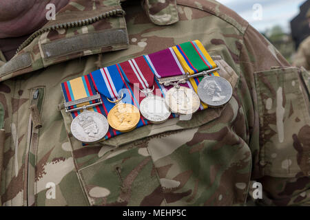 Warrington, UK, 22 April 2018. Medals worn on the chest of a Senior Officer from The Queen's Lancashire Regiment in camouflage kit on ANZAC day in Soldiers' Corner of Warrington Cemetery on Sunday 22 April 2018 Credit: John Hopkins/Alamy Live News Stock Photo