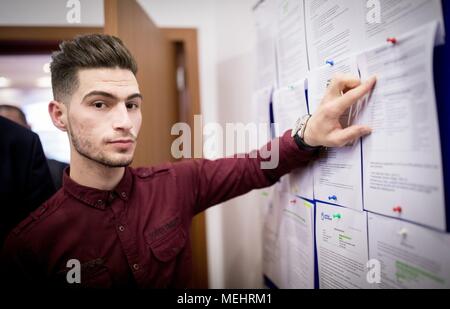 22 April 2018, Erbil, Iraq: Mustafa, a refugee returned from Germany to Erbil, showing job offers on an information board after the opening of a migration advisory center. Photo: Kay Nietfeld/dpa Stock Photo