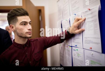 22 April 2018, Erbil, Iraq: Mustafa, a refugee returned from Germany to Erbil, showing job offers on an information board after the opening of a migration advisory center. Photo: Kay Nietfeld/dpa Stock Photo