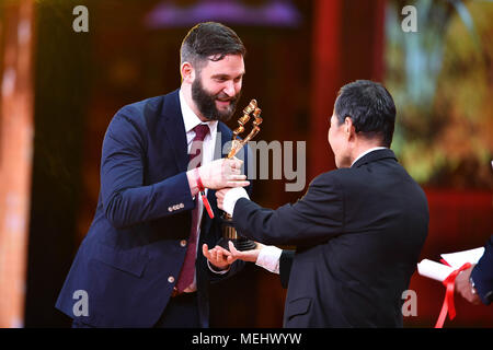 Beijing, China. 22nd Apr, 2018. Actor Li Xuejian (R) presents the Best Actor award to a representative on behalf of actor Joe Cole, who starred in 'Eye on Juliet', at the awarding ceremony of Tiantan Award 2018 during the 8th Beijing International Film Festival (BJIFF) in Beijing, capital of China, April 22, 2018. The award winners of Tiantian Award 2018 were announced during the 8th BJIFF on Sunday. Credit: He Changshan/Xinhua/Alamy Live News Stock Photo