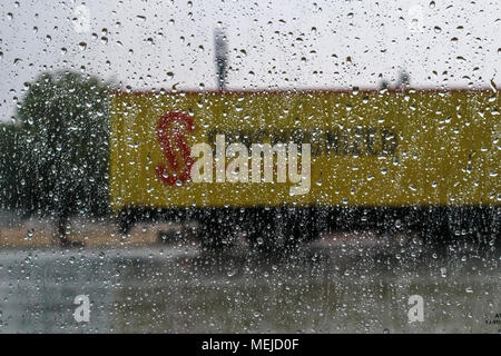Raindrops on the outside of a car window with a yellow road haulage lorry in the background during a rainstorm in Dausa, Rajasthan, north India Stock Photo