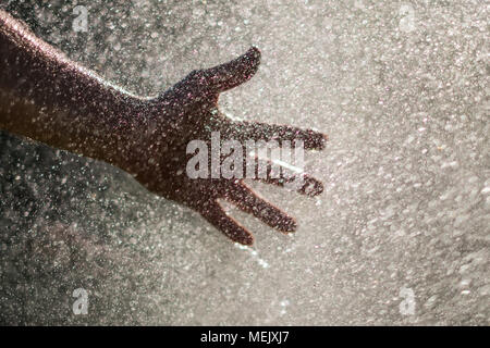 Water drops and hand - holding hand in water splash Stock Photo