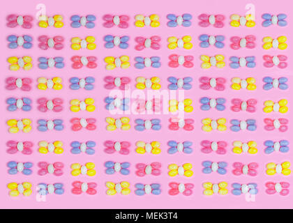 Pastel colored jelly beans in a Knolling pattern format with a pretty pink background repeating, Stock Photo