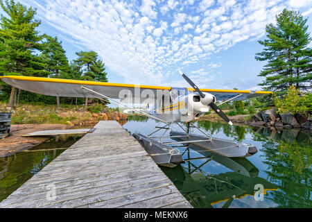 A Piper PA-18 Super cub, on floats, tied to a dock in Northern Ontario Stock Photo