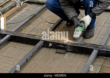 worker in gloves cleans the angle grinder metal construction.Copyspace left Stock Photo