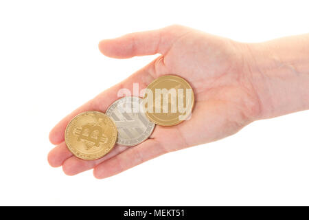 Three kinds of cryptocurrency, litecoin, ripple and bitcoin lying on a female hand on a white background Stock Photo