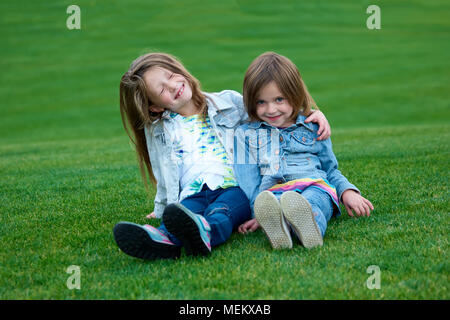Two friends girls lying on the meadow. Stock Photo