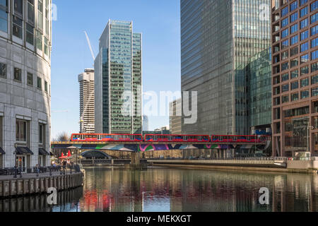 LONDON, UK - APRIL 05, 2018:  Docklands Light Railway (DLR) train passing offices Stock Photo