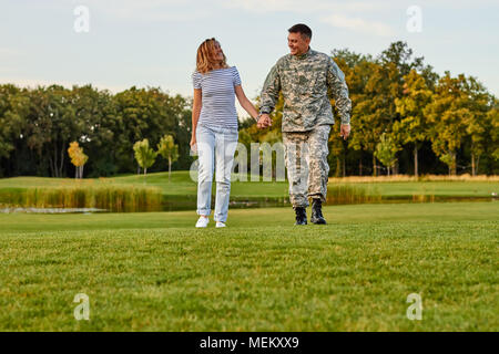 Soldier with girlfriend walking holding hands. Stock Photo