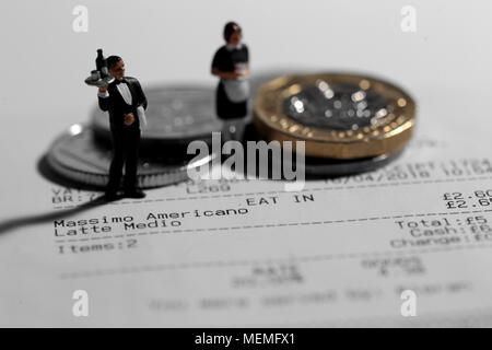 Miniature scale model waiter and waitress on a till receipt bill with british coins tip Stock Photo