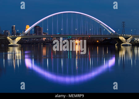 The Lowry Avenue Bridge glows with purple light for the first anniversary of Twin Cities icon Prince.  The city skyline of Minneapolis is visible in t Stock Photo