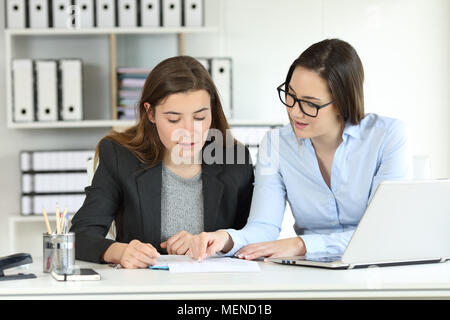 Two concentrated office workers coworking talking about documents on a desktop Stock Photo