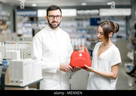 Pharmacist with client and first aid kit in the pharmacy Stock Photo