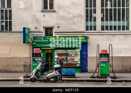 A petrol pump attendant refuels a scooter at a Petrol station on Boulevard de Clichy, Pigalle,Montmartre,Paris Stock Photo