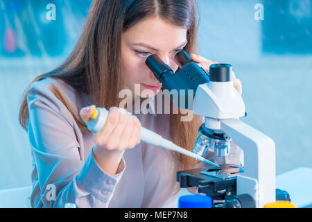 Young chemist in the laboratory. Scientist Using Microscope In Lab Stock Photo