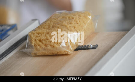 Food industry - conveyor with plastic pack of macaroni Stock Photo