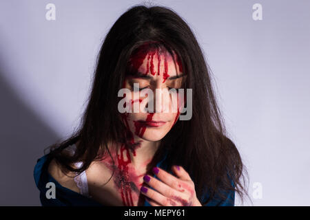 Beaten young woman with bruises and blood on her face. Abuse and violence concept Stock Photo