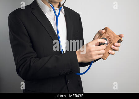 business man using stethoscope for wallet Stock Photo