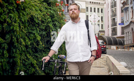 Portrait of stylish man walking to work with bicycle Stock Photo
