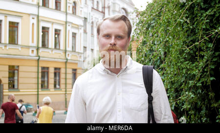 Portrait of handsome young man with beard posing on stret of old town Stock Photo