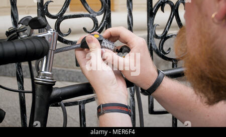 Closeup image of young man locking bicucle with combination lock Stock Photo