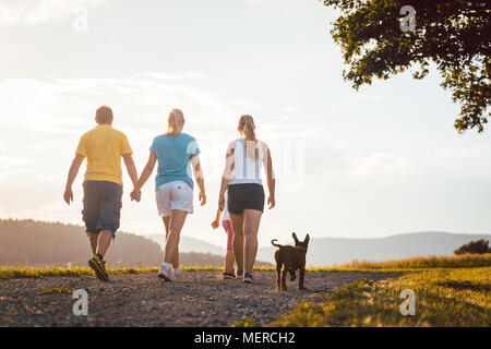 Family and dog walking home Stock Photo