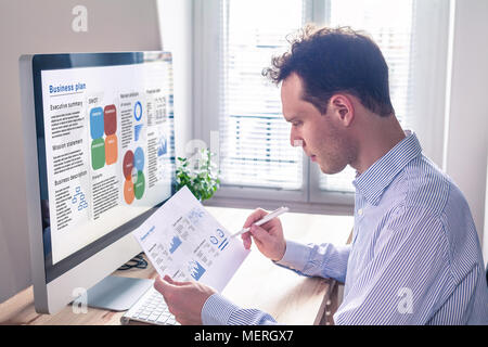 Businessman working on a business plan on computer screen in office with executive summary, mission statement, SWOT, market analysis, and financial re Stock Photo