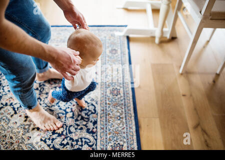 Father with a baby girl at home. First steps. Stock Photo