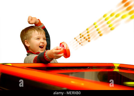 A child who has won his air hockey game, with a red mallet in his hand. Stock Photo