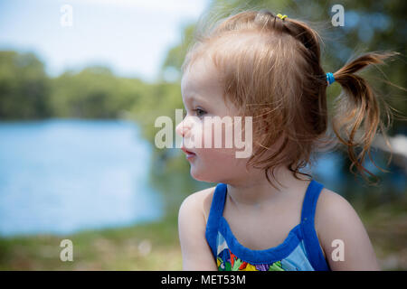 Infant playing outside by a lake Stock Photo