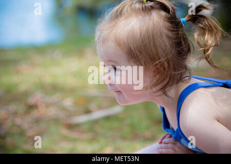 Infant playing outside by a lake Stock Photo