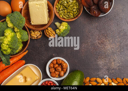 Healthy food nutrition dieting concept. Assortment of high vitamin A sources. Carrots, nuts, broccoli, butter, cheese, avocado, apricots, seeds, eggs. Stock Photo