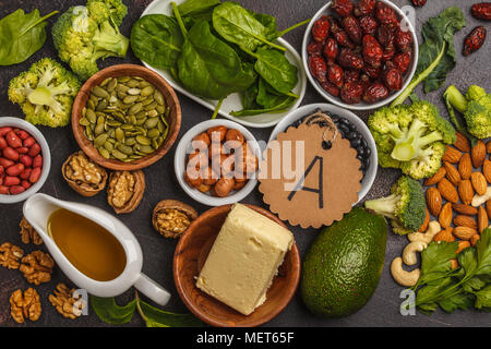 Healthy food nutrition dieting concept. Assortment of high vitamin A sources. Carrots, nuts, broccoli, butter, cheese, avocado, apricots, seeds, eggs. Stock Photo