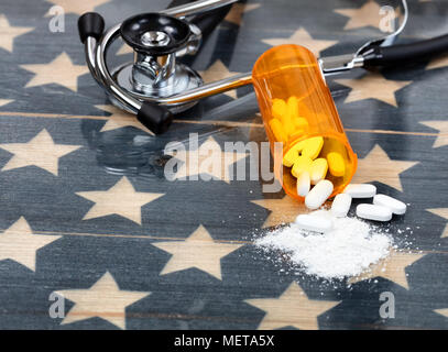 Close up front view of prescription bottle with generic opioid pain killer tablets. Rustic USA flag and medical stethoscope in background for drug add Stock Photo